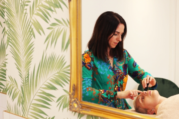 Donna Ryan plucks lady's eyebrows in her holistic facial practice