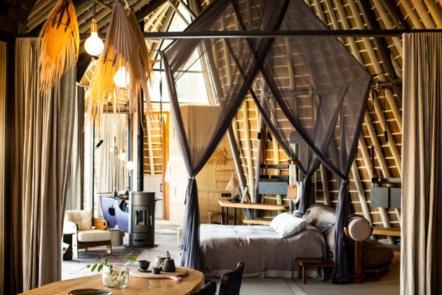 inside a safari-style lodge bedrooms set up with canopy over the bed 
