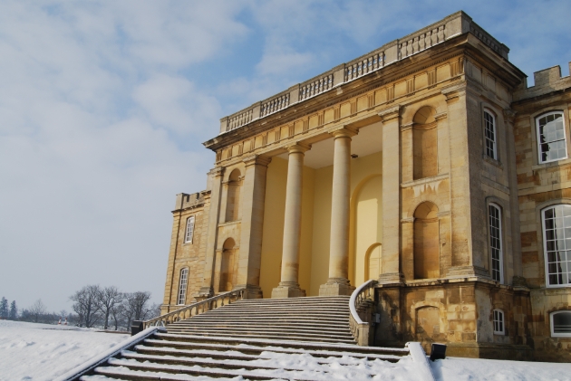 Kimbolton Castle, front of historic building with steps leading down to snow covered lawn