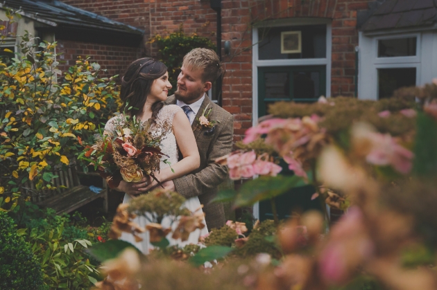 couple in wedding outfits standing in their garden