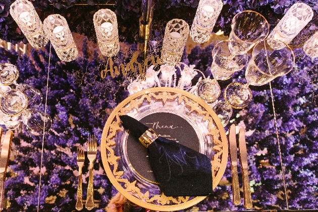 table setting with crystal glassware and purple blooms