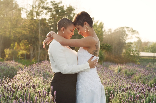 two brides hugging standing in a field