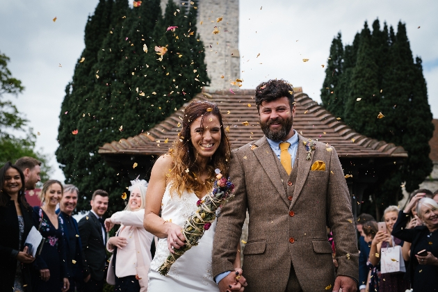 couple leaving church after wedding with confetti thrown in the air