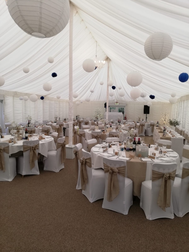 inside a large white marquee set up for a wedding