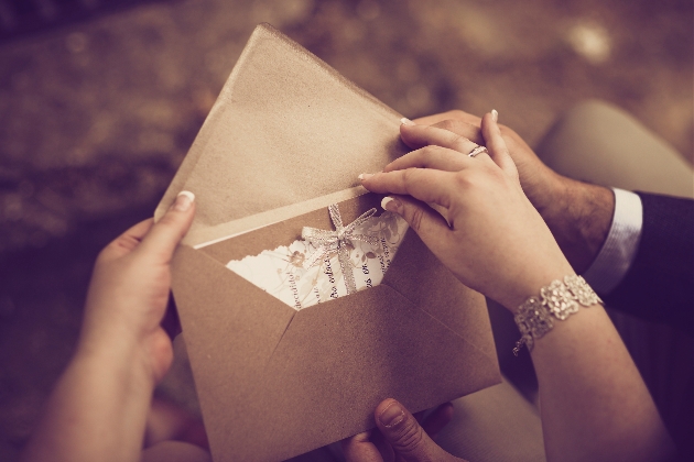 a hand pulling an invite out of an envelope