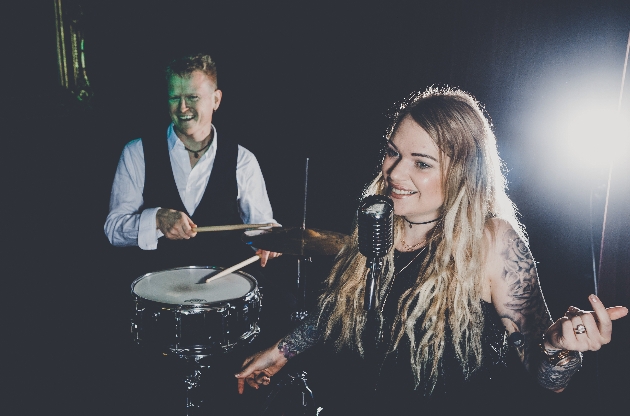 female singer and man playing the drums