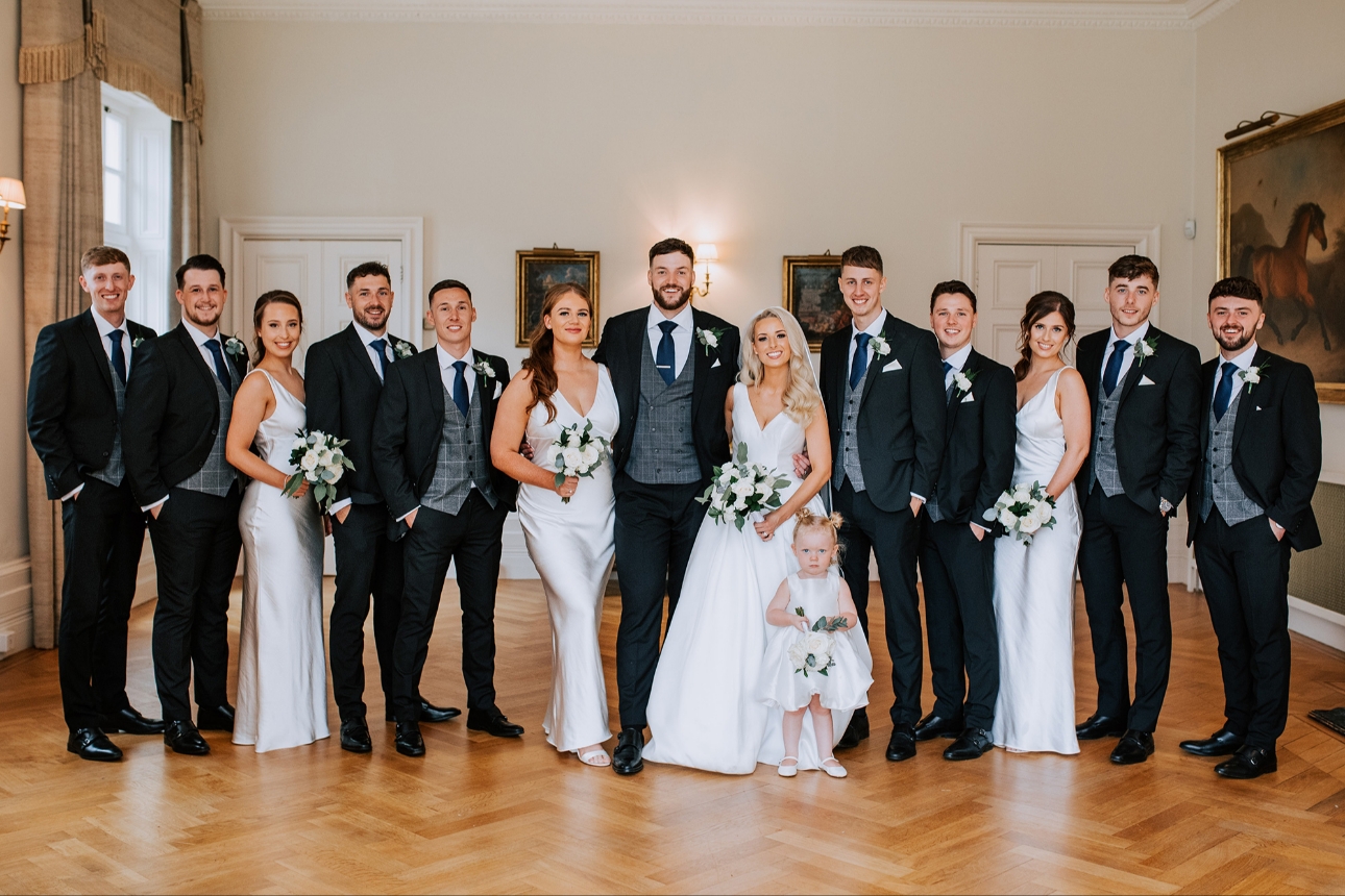 Couple pose with bridesmaids and groomsmen