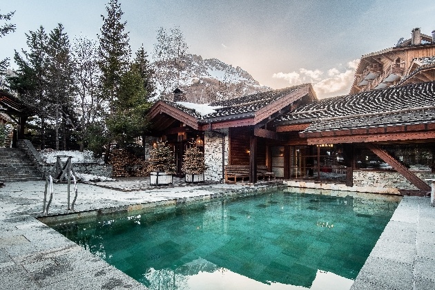 log cabin in snowcapped hills with outdoor heated pool