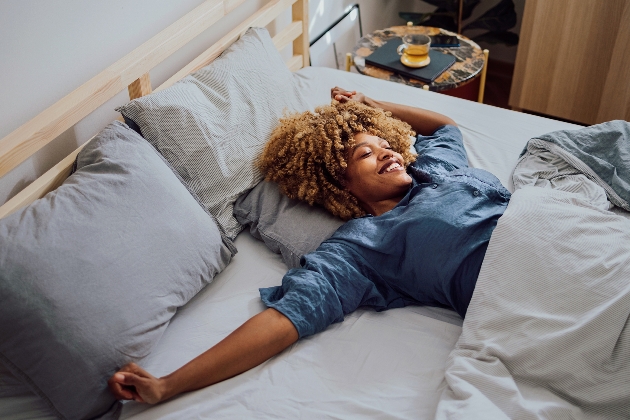 woman waking up in bed looking happy