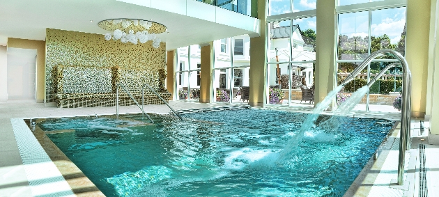 An indoor swimming pool in a room decorated with gold and white colours