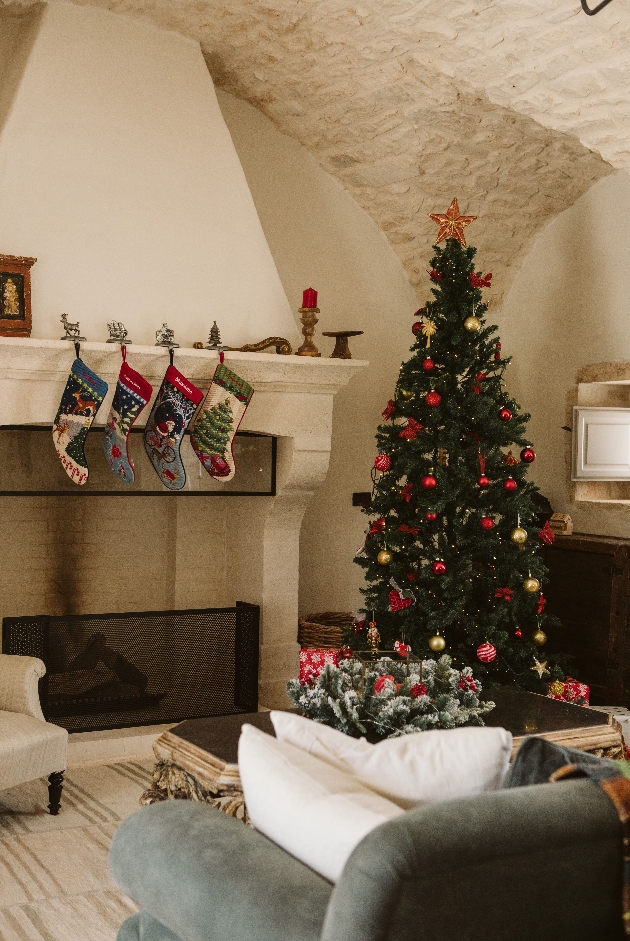 A living room with a Christmas tree and four stockings