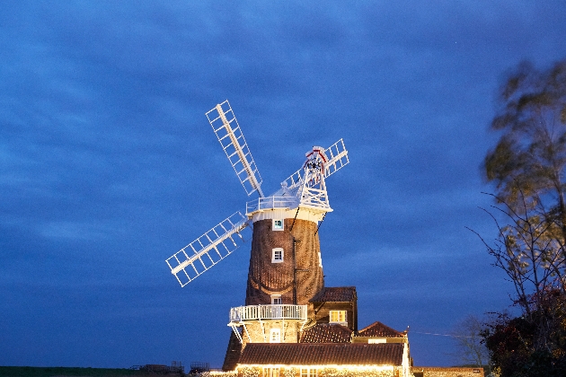 The exterior of a windmill which is illuminated by lights