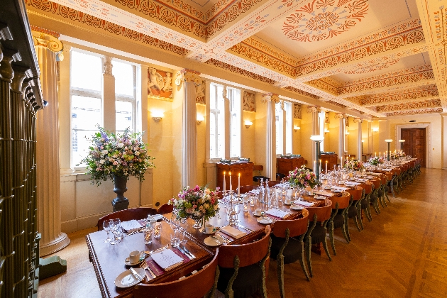 A large room with painted ceilings and a large, long table running down the length of the room