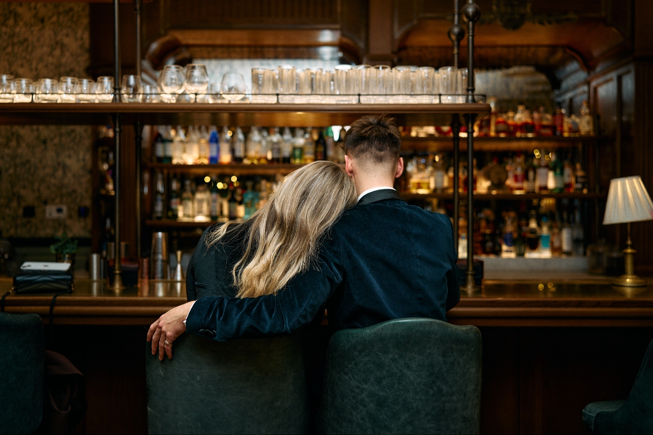 The backs of a woman and man sitting at a bar