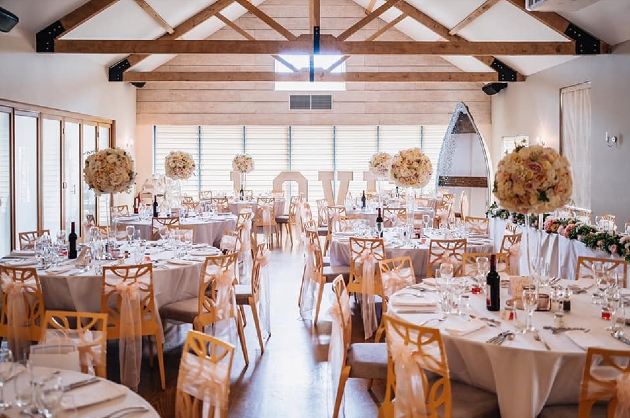 A wedding breakfast set up in a large, light-filled room
