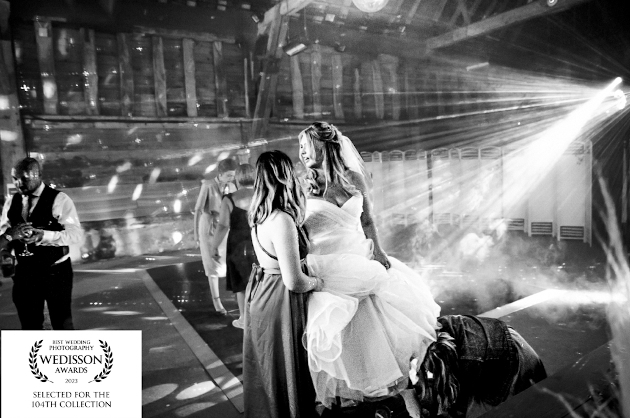 A black and white image of a bride on the dancefloor with her bridesmaid