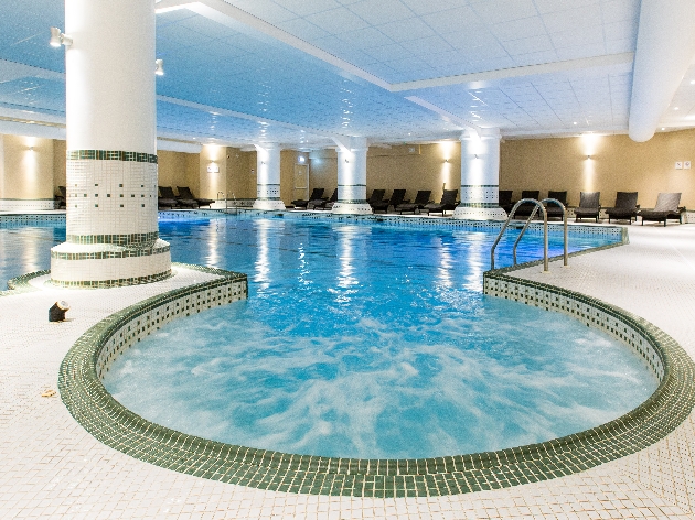 A large indoor swimming pool with a whirlpool 