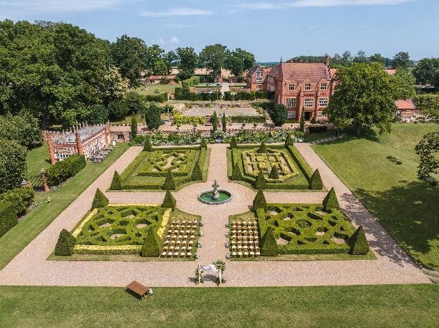 Manicured gardens with a manor house in the background
