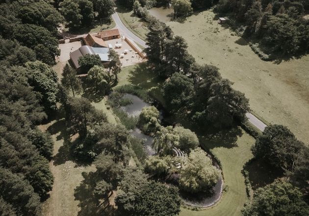 A sky view of a forest with a venue hidden amongst the trees
