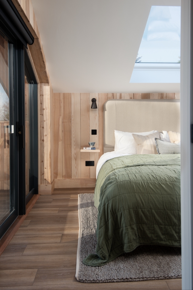 bed with green bedding in well lit room 