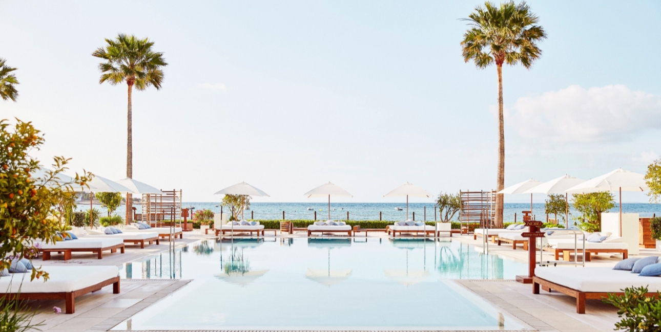 image of pool with palm trees and sun loungers 