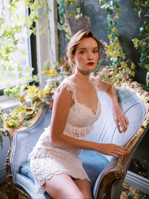 woman in short white dressing posing on blue sofa