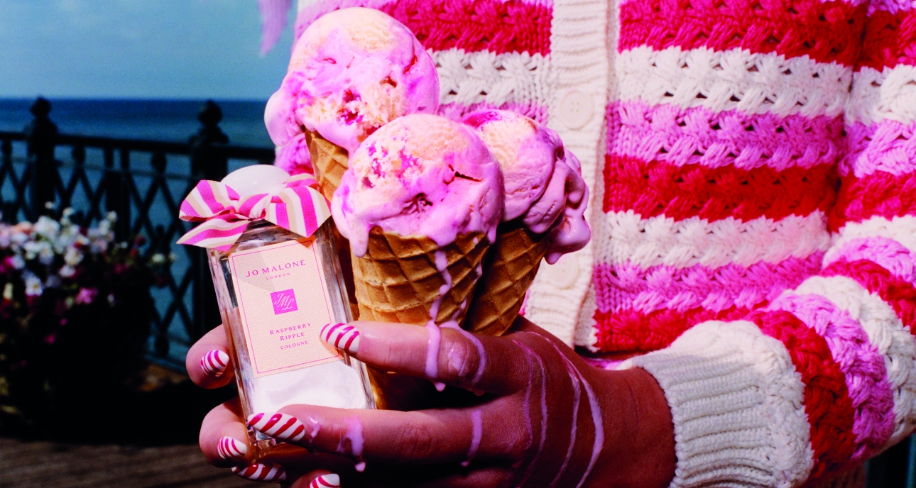 woman with pink and white nails holding raspberry ripple ice creams and new Jo Malone Raspbery Ripple fragrance at the seaside