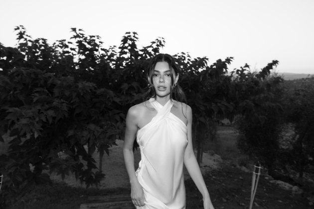 woman in halter neck dress posing outside