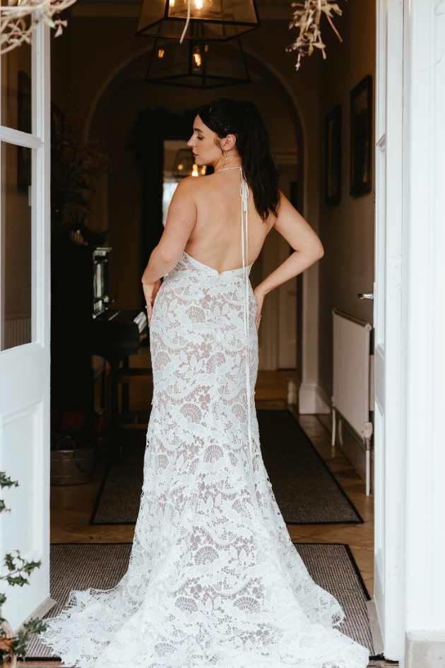 woman in lacy wedding dress posing in open doorway 