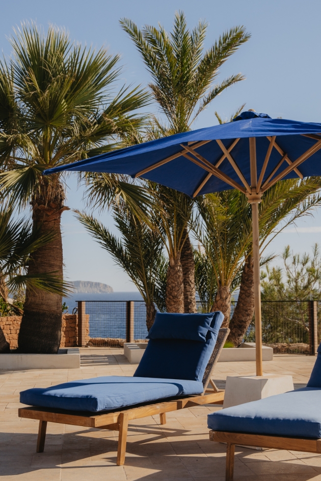 blue sun loungers and parasol by a pool