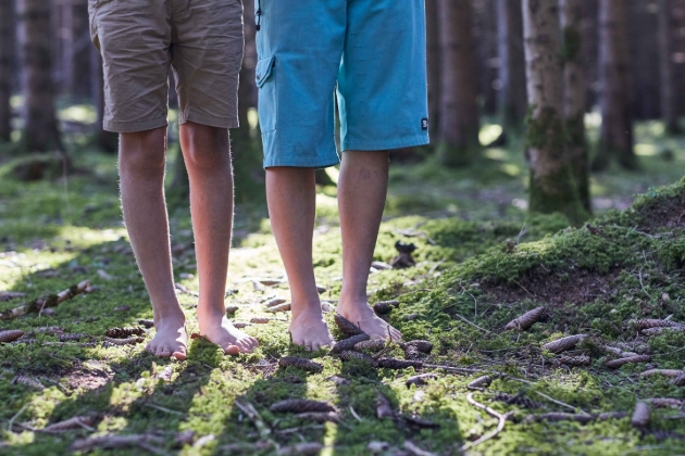 two people barefoot in the woods