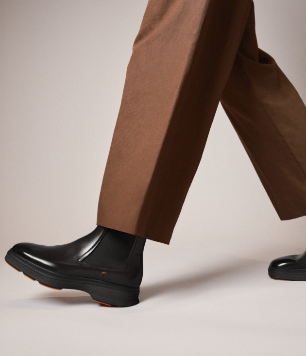 person in brown trousers and black boots