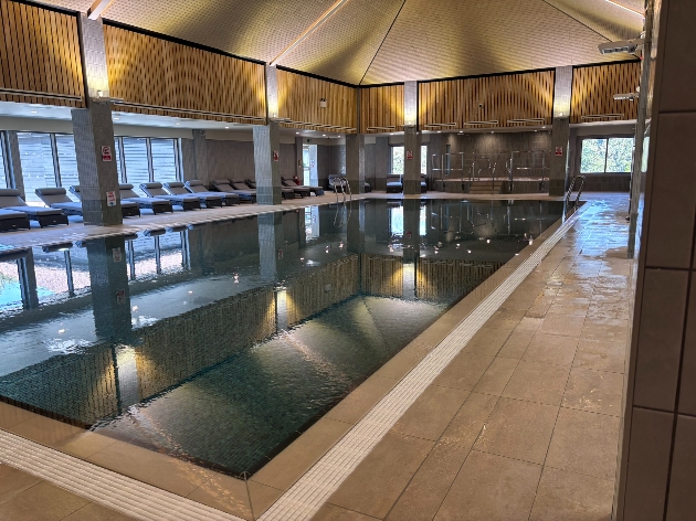 An indoor swimming pool surrounded by loungers
