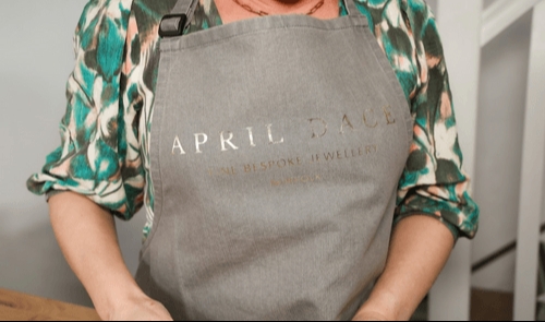 A woman wearing an apron that reads April Dace Jewellery