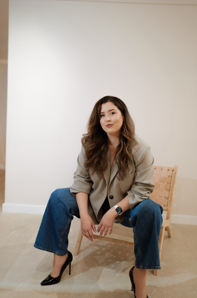 A woman sitting on a chair looking at the camera