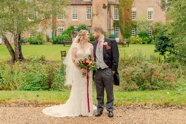 A bride and groom looking at each other in a beautiful garden